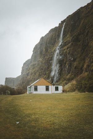 Rural house at foot of huge mossy cliff