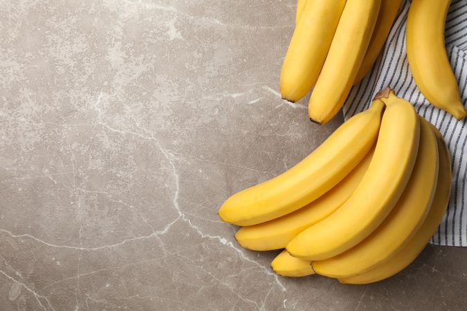 Towel and bananas on gray background. Fresh fruit