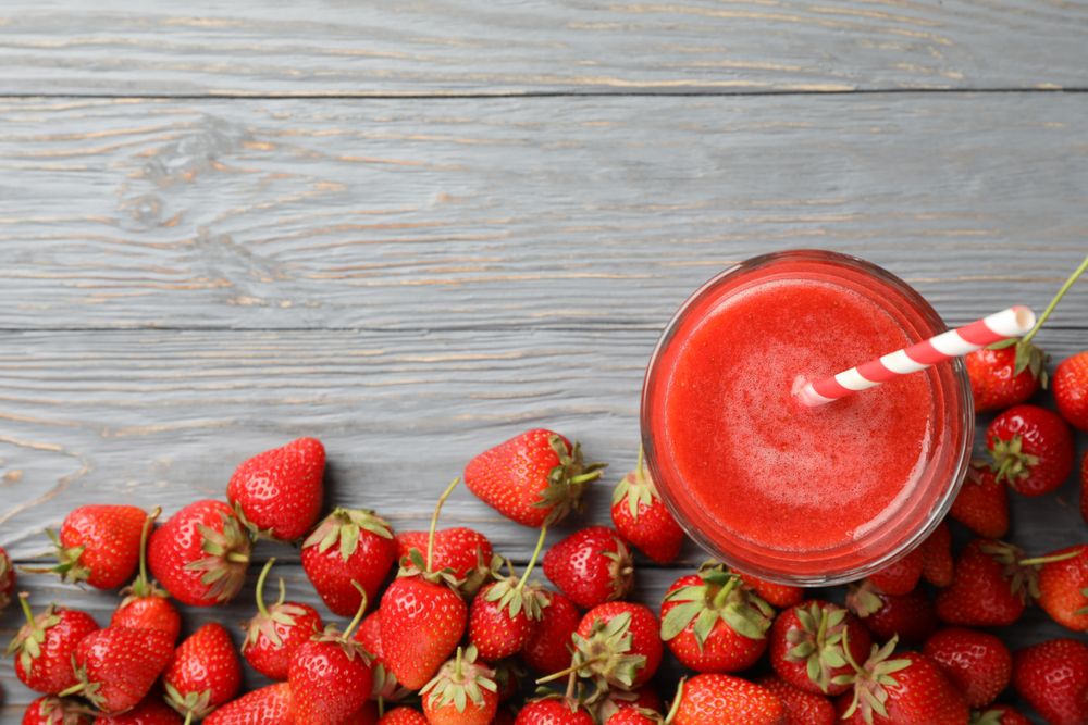 Tasty strawberry and cocktail on wooden background, top view. Summer berry