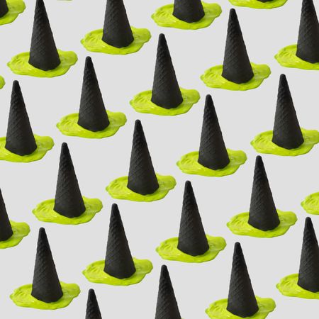 Rows of green ice cream melting under dark cone in halloween concept