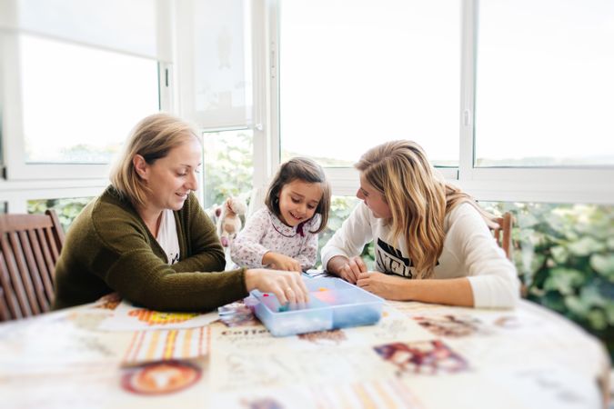 Woman playing board game with daughter and granddaughter