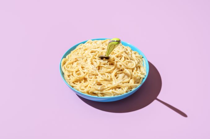 Cheese spaghetti bowl isolated on a purple background