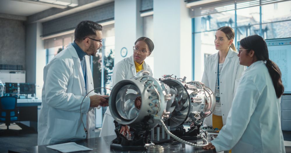 Team of Industrial Engineers Working on a Futuristic Jet Engine, Discussing in Scientific Technology Lab.