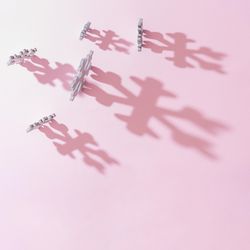 Wooden snowflakes Christmas tree decoration with pink background with shadows