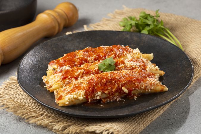 Pancakes stuffed with minced meat and topped with tomato sauce and grated cheese.