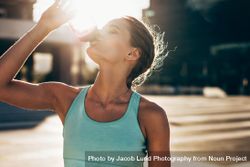 Woman drinking water after workout session 0JGNOr