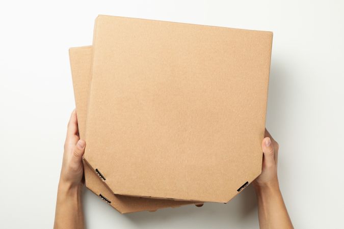 Hands hold boxes with tasty pizza, top view