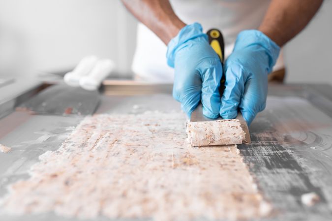 A worker is using a spatula to roll an ice cream on a freeze machine