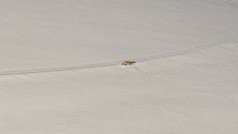 Winter scenery, drone aerial view, with single bench in deep snow nature