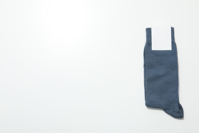 Socks with blank label on light background, space for text