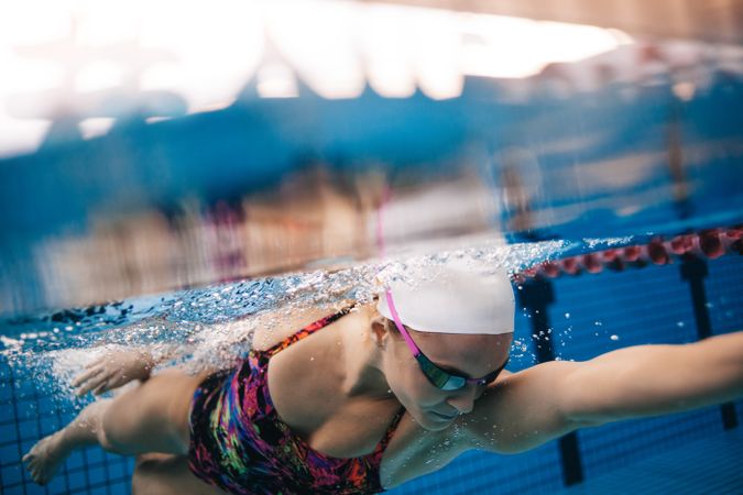 Skilled female swim coach taking a lap in pool