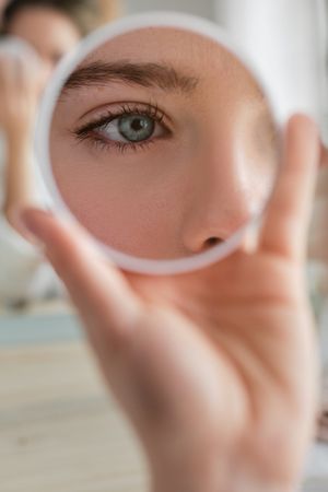 Anonymous woman with round mirror