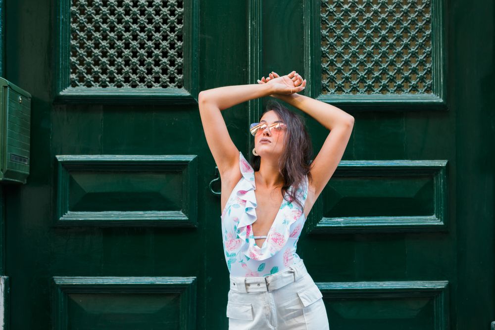 Confident stylish woman in sunglasses standing on city street