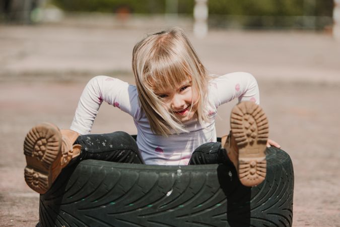 Little girl sitting inside tire