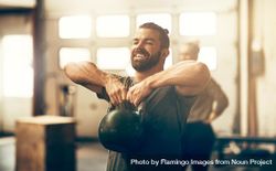 Man lifting kettlebell in gym 4m73X0