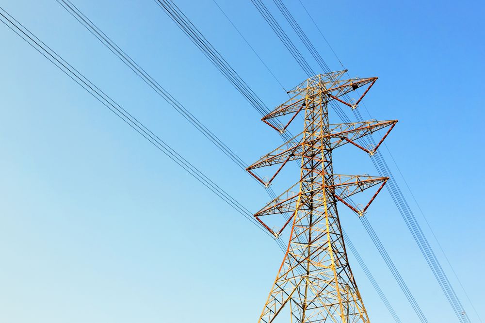 Power Transmission Tower Against Clear Blue Sky on a Sunny Day