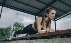 Sportswoman doing plank on a bench