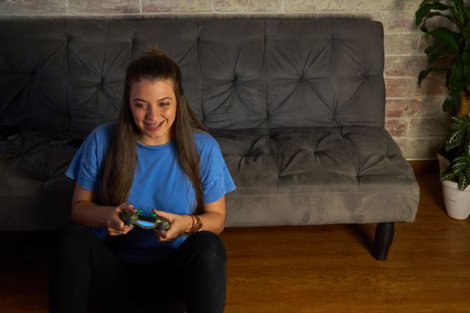 Woman in blue T-shirt playing videogame