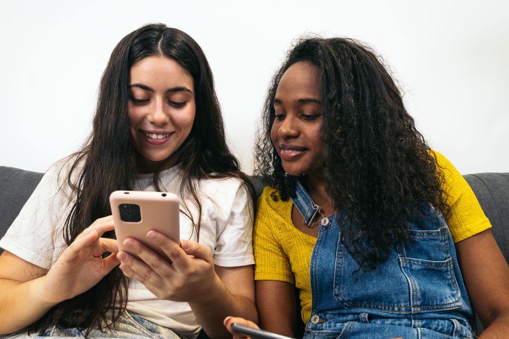 Friends enjoying digital devices together