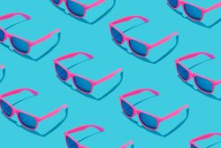 Pattern of pink sunglasses on blue background