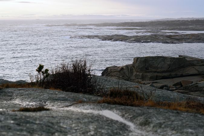 Rocky seashore and dark wavy sea in dusk