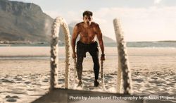 Fit male doing high intensity workout on the beach 4Nzee4