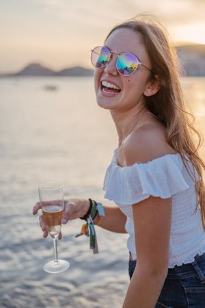 Young woman enjoying wine near sea