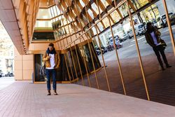 Stylish guy using smartphone outside modern building