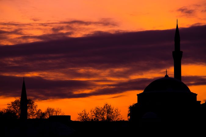Dark mosque against vibrant sunset sky