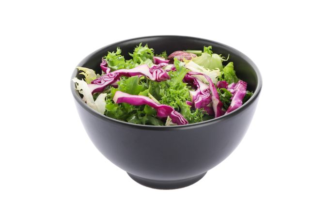 Black bowl with fresh salad isolated on blank background