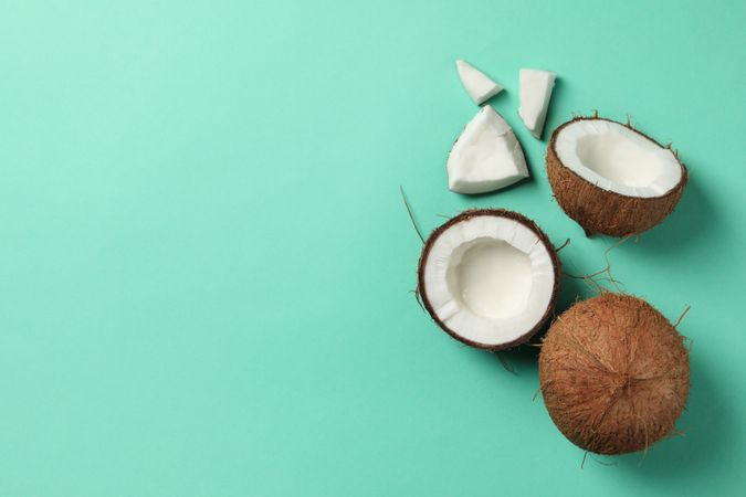 Coconut on mint background, top view and space for text