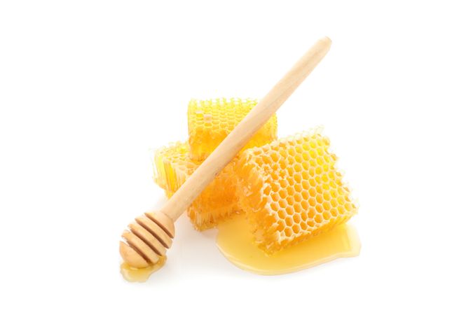Pieces of honeycomb and dipper isolated on plain background