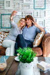 Couple taking selfie on a sofa