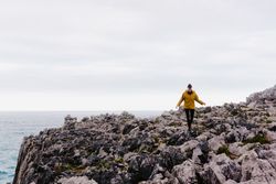 Traveler in solitude walking on rocky shore