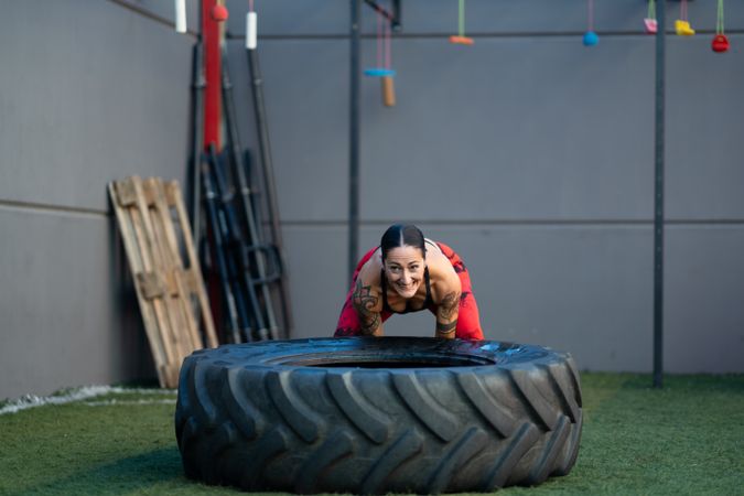 Athletic woman working out with tire