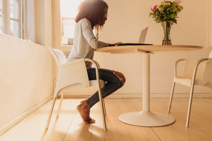 Woman entrepreneur managing her business from home working on laptop computer