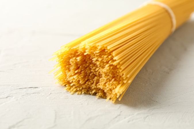 Pasta on light background, space for text and closeup. Uncooked whole wheat pasta