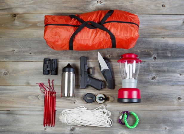 Personal protection and camping gear on aged wood