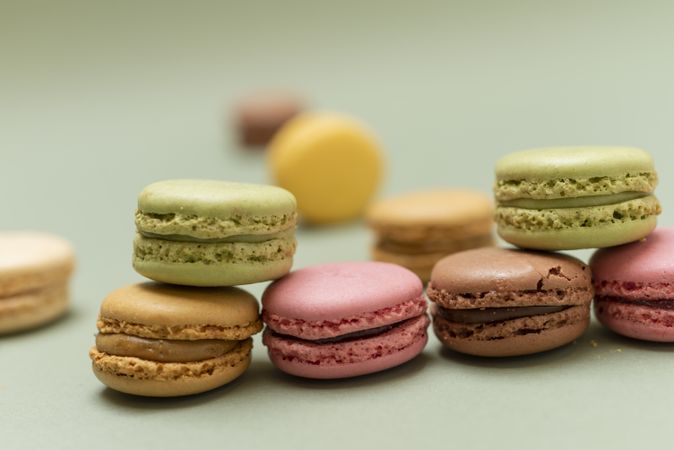 Pile of pastel colored macaroons over a green background