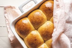 Bread buns freshly baked covered with a kitchen towel