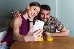 Smiling couple taking selfie in kitchen