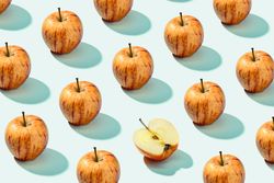 Half apple in row with whole apples