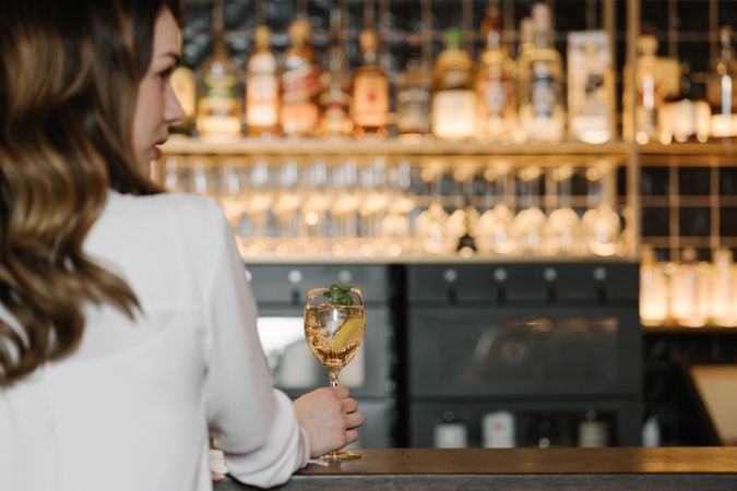 Young woman enjoying cocktail in bar