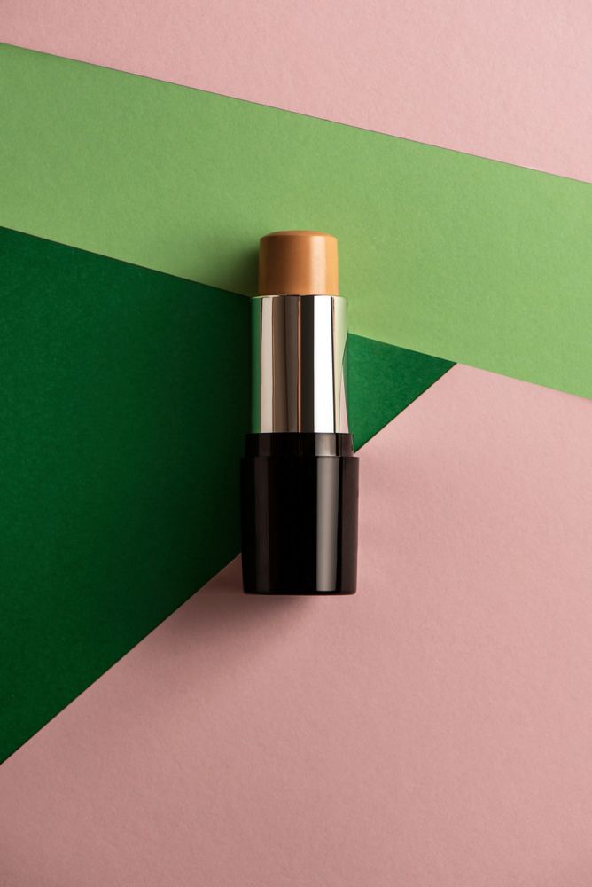 Concealer stick on modern background with geometric shapes.