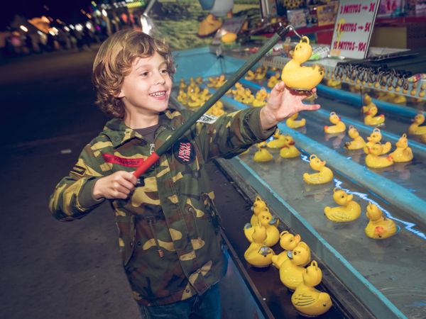 Kid catching rubber duck in amusement park