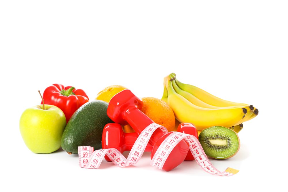 Dumbbells, measuring tape and fruits isolated on plain background