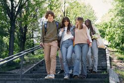 Happy students walking down stairs on campus