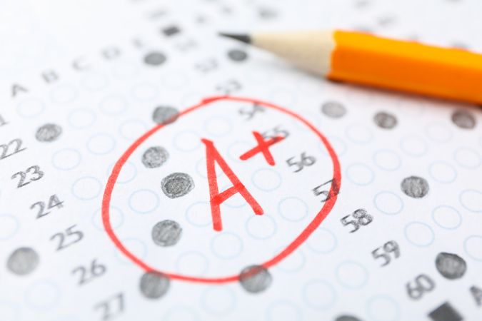 Pencil laying on completed multiple-choice exam with a A+ grade