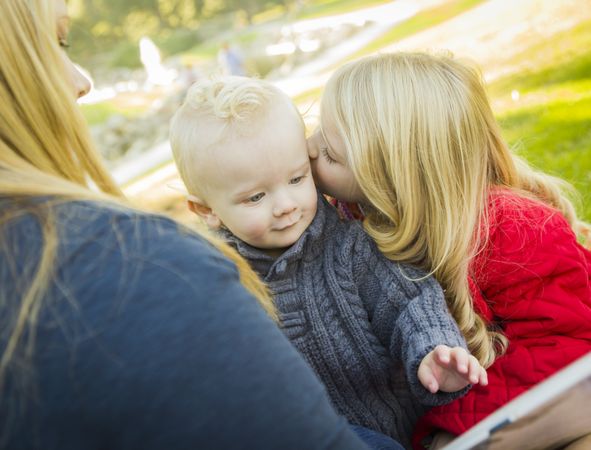 Mother Reading a Book to Her Two Adorable Blonde Children.