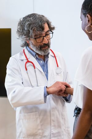 Doctor measuring pulse of patient